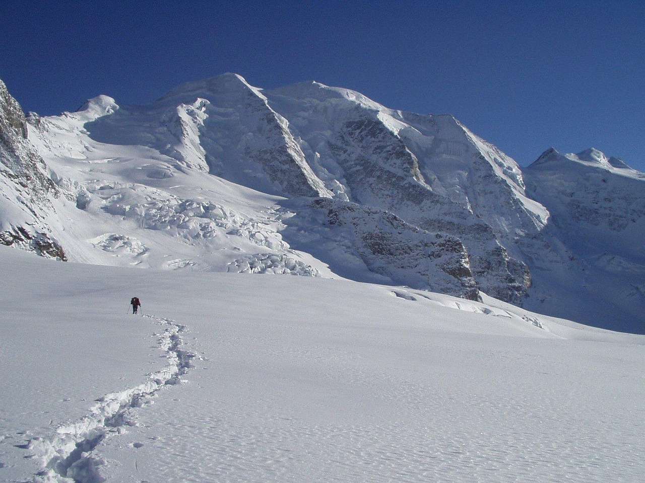 Promeneur marchant dans la neige sur un sentier du Queyras en hiver.