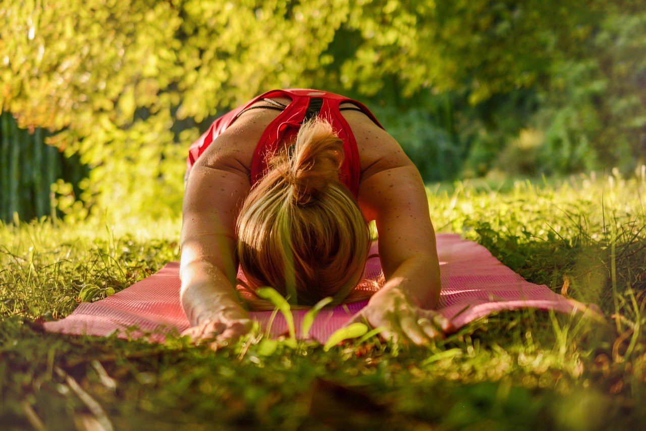 Femme en posture de yoga face aux sommets du Queyras sous le soleil du matin.