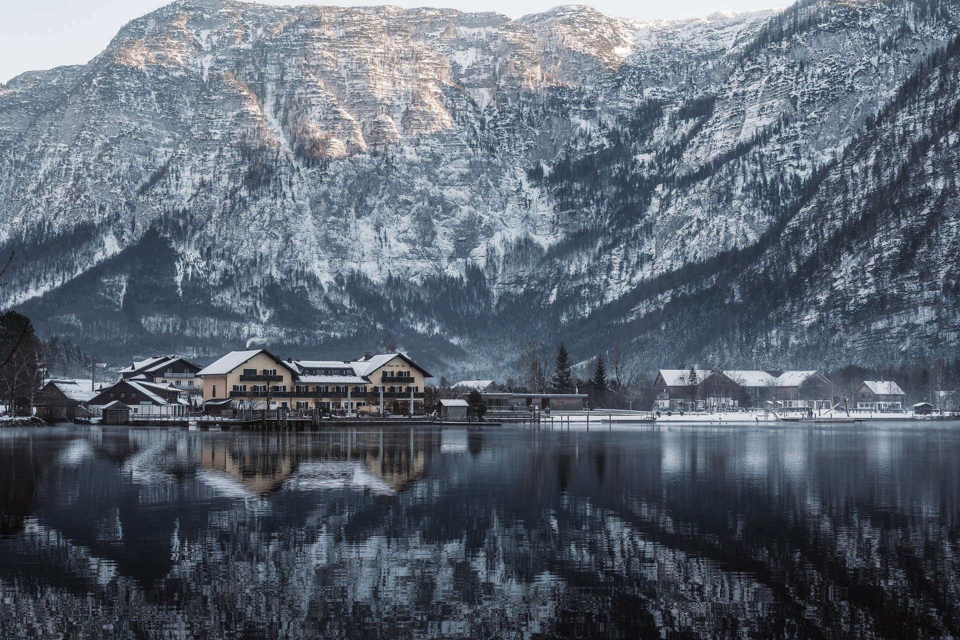 Village de montagne enneig&eacute; avec reflet sur un lac