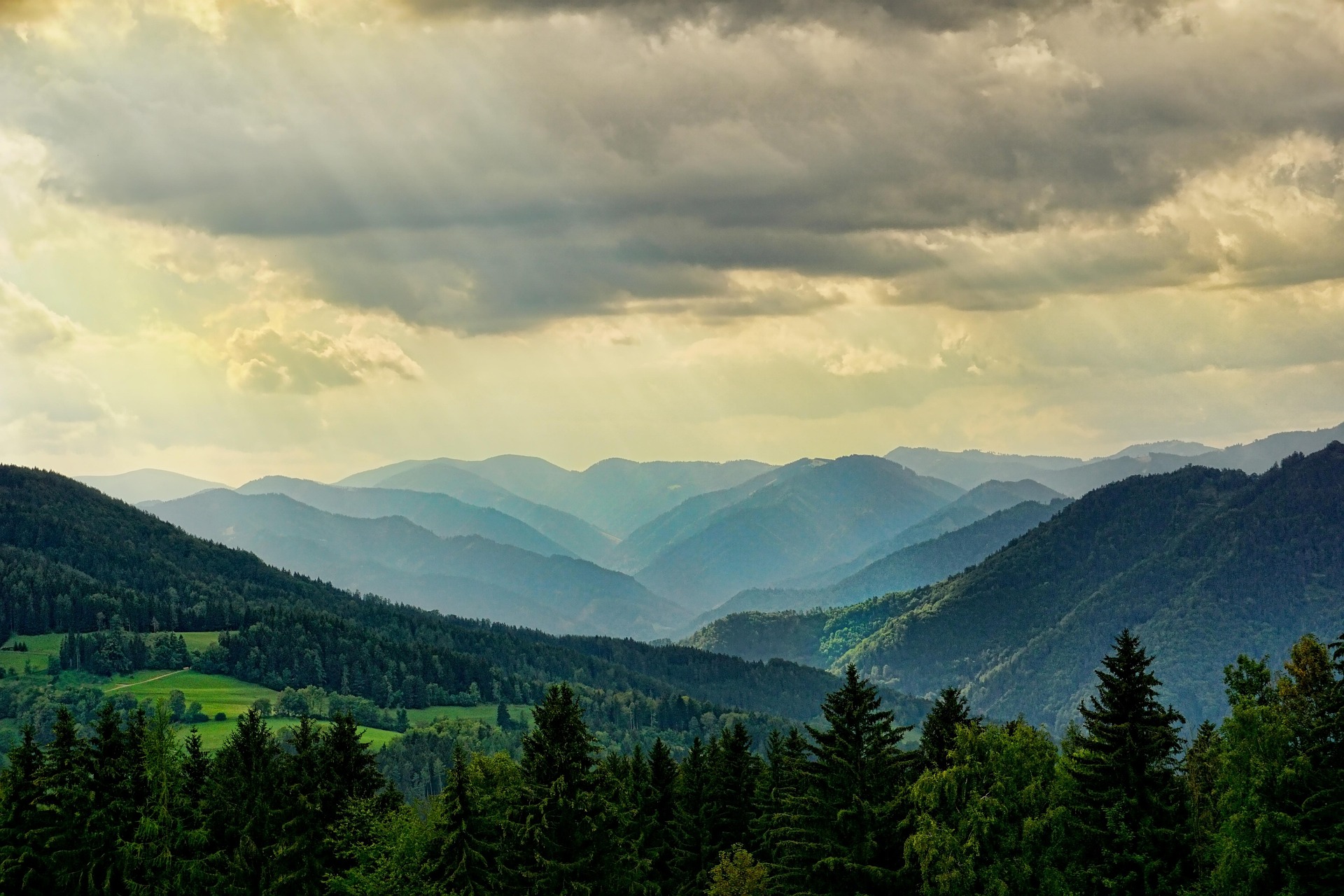 Cha&icirc;ne de montagnes verdoyantes sous un ciel nuageux